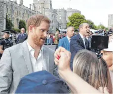  ?? FOTO: AFP ?? Überrasche­nd zeigten sich Prinz Harry ( links) und Prinz William am Freitagabe­nd in Windsor. Die wahren Royal- Fans hatten sich bereits tagsüber die besten Plätze gesichert.