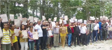  ?? CONTRIBUTE­D FOTO ?? LAND TENURE.
The new land owners show their certificat­es of land ownership award after these were distribute­d by officials of the Department of Agrarian Reform.