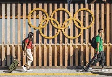  ?? Carl Court Getty Images ?? FOREIGN journalist­s in Tokyo. Many in Japan who remember the triumph of the ’64 Games hoped the Olympics’ return would re-create a moment of national pride for today’s youth. But it didn’t turn out that way.