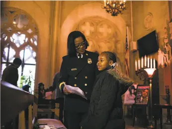  ?? Mason Trinca / Special to The Chronicle 2017 ?? Oakland Fire Chief Teresa Deloach Reed talks to Lovely Hudson, 7, before an Oakland NAACP community event during Black History Month in 2017.