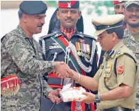  ?? AFP ?? India’s BSF Commandant Sudeep presents sweets to Pakistani Wing Commander Bilal at the Wagah border post on Tuesday. —