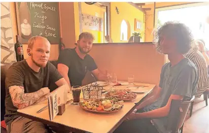  ?? FOTO: WOW ?? Nils Berger (von links), Lukas Saal und Leon Becker freuen sich darüber, nun auch wieder im Innenberei­ch von La Casa de las Tapas zu Abend essen zu können. Viele Gäste nutzten allerdings den Sonnensche­in vor der Türe.