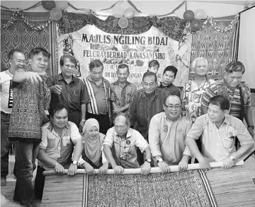  ??  ?? Salang (front row, centre) leads Felcra officials and landowners in the ‘ngiling bidai’ ceremony.