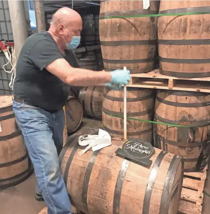  ?? PURE MEMPHIS HONEY ?? Roger Hunter of Pure Memphis Honey checks on the barrel of bourbon-aged honey while it aged at B.R. Distilling Co. for four months in the summer of 2020.