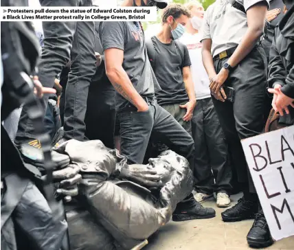  ??  ?? > Protesters pull down the statue of Edward Colston during a Black Lives Matter protest rally in College Green, Bristol