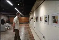  ?? (Arkansas Democrat-Gazette/Thomas Saccente) ?? Jarrod Cluck takes in the works of Her Voice earlier this month during an opening reception at the District Galleries in downtown Fort Smith.