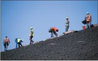  ??  ?? Workers prepare the roof at Bethel Church in San Jose for the installati­on of solar panels in 2016.