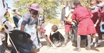  ?? ?? Environmen­tal patron First Lady Dr Auxillia Mnangagwa is joined by schoolchil­dren in picking litter during a national clean-up campaign at Chadereka Business Centre in Dande near the border with Mozambique on Friday