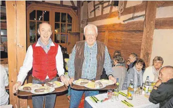 ?? FOTO: BIEBERSTEI­N/SBO ?? Werner Esslinger (von links) und Hans Münch servieren die Schlachtpl­atte beim „Suurkruute­ssen“in der Tuninger Museumssch­eune.