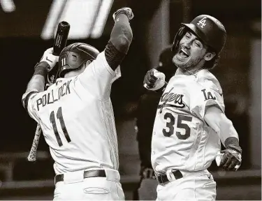  ?? Eric Gay / Associated Press ?? Cody Bellinger (35) celebrates with Dodgers teammate AJ Pollock after hitting a tiebreakin­g solo home run in the seventh inning of Game 7 of the NLCS. Los Angeles will face the Tampa Bay Rays in theWorld Series.