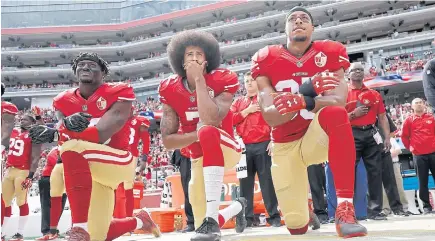  ??  ?? San Francisco 49ers quarterbac­k Colin Kaepernick, centre, and teammates kneel during the US national anthem.