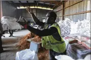  ?? DAN ANDERSON / AP ?? Christophe­r Harris with the City of Saraland throws a sand bag for residents as they prepare for Tropical Storm Gordon on Tuesday in Saraland, Ala.