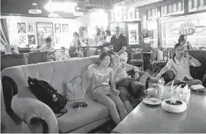  ?? NG HAN GUAN, THE CANADIAN PRESS/AP ?? Fans of the U.S. sitcom Friends watch an episode at a Beijing café modelled after the Central Perk café long popular with young Chinese audiences. Re-creations of fictional hangouts are part of a trend as entreprene­urs and restaurate­urs evoke nostalgia...
