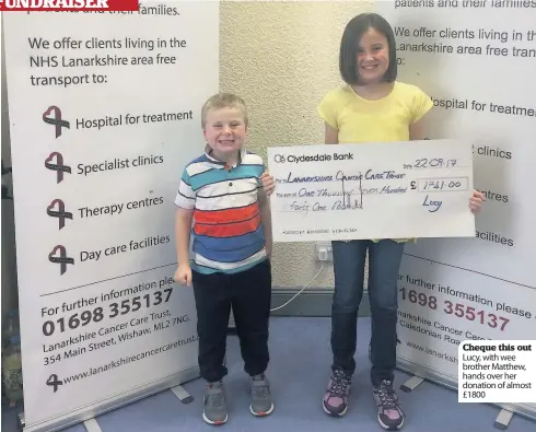  ??  ?? Cheque this out Lucy, with wee brother Matthew, hands over her donation of almost £1800