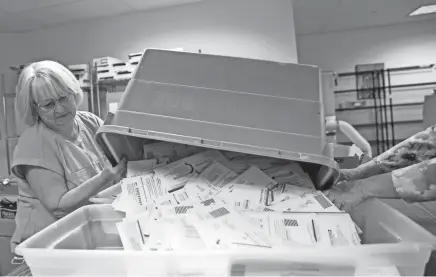  ?? ABIGAIL DOLLINS/STATESMAN JOURNAL VIA IMAGN CONTENT SERVICES, LLC ?? Election clerk Patti Butler unloads a tub of mail-in ballots to be sorted Monday at the Marion County Clerk’s Office in Salem, Oregon.