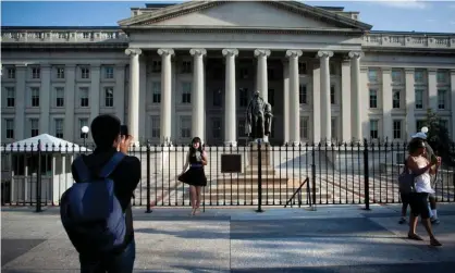  ??  ?? A tourist poses in front of the US treasury department in Washington DC. Photograph: Brendan Smialowski/EPA