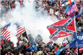  ?? Photograph: Shannon Stapleton/Reuters ?? Protesters wave Confederat­e and Trump flags as they storm the US Capitol on 6 January 2021.