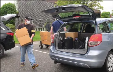  ?? Ernest A. Brown photo ?? Lead organizer Steve Cranshaw, left, and Jason McKenna, stock boxes of food that were to be distribute­d to families in need in the parking lot at Lime Rock Baptist Church in Lincoln Saturday morning.