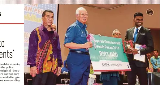  ?? PIC BY OSMAN ADNAN ?? Prime Minister Datuk Seri Najib Razak presenting the Tokoh Guru award to Samuel Isaiah during the Pekan-level celebratio­n for Teachers Day and Education Excellence at DRB-Hicom University of Automotive Malaysia in Pekan yesterday.