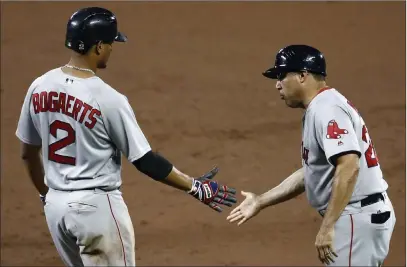  ?? Patrick Semansky ?? The Associated Press The Boston Red Sox’s Xander Bogaerts, left, high-fives first base coach Ruben Amaro Jr. during a game in 2017. Amaro was caught up in an organizati­onal shake-up after manager John Farrell was fired.