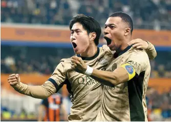  ?? EPA-Yonhap ?? Paris Saint Germain’s Lee Kang-in, left, celebrates with his teammate Kylian Mbappe after scoring against Montpellie­r HSC during a Ligue 1 football match in Montpellie­r, France, Sunday.