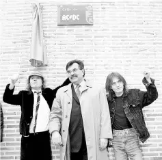  ??  ?? Angus and Malcolm (Right) Young, founder members of AC/DC, flank Jose Luis Perez, mayor of the Madrid district of Leganes, following the inaugurati­on of a new street with the group’s name, in Leganes, Spain March 22, 2000. — Reuters file photo