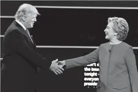  ??  ?? Republican presidenti­al nominee Donald Trump and Democratic presidenti­al nominee Hillary Clinton shake hands during the presidenti­al debate at Hofstra University in Hempstead, N.Y., on Monday.