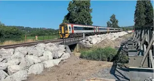  ?? NETWORK RAIL ?? With No. 158832 nearest the camera, a trio of Transport for Wales Class 158s pass the worksite between Welshpool and Newtown, the rock armour prominent along the embankment.