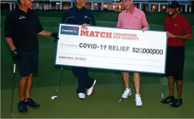  ?? GETTY IMAGES ?? Awesome foursome: Mickelson, Brady, Manning and Woods in near darkness at the Medalist with a cheque for $20million for Covid-19 charities