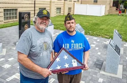  ?? Alexandra Wimley/Post-Gazette ?? Ed Miller and his son, Steve, display the flag of Ed's late father, Fred Miller, at the memorial outside of the KeithHolme­s VFW Post 402 in Coraopolis that will be dedicated on Memorial Day.