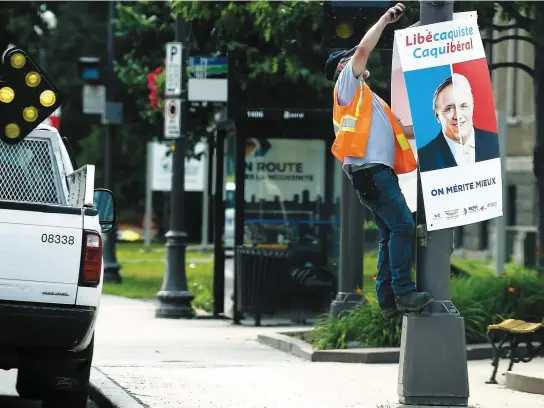 ?? PHOTO JEAN-FRANÇOIS DESGAGNÉS ?? Les cols bleus de la Ville de Québec ont retiré hier une à une les affiches qui avaient été installées sur les poteaux la semaine dernière par la coalition syndicale qui dénonce les libéraux et les caquistes.