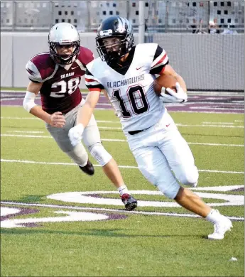  ?? TIMES photograph by Annette Beard ?? Blackhawk senior Carson Rhine (No. 10) outmaneuve­red Siloam Springs Panther defenders Friday night as he ran down the field.