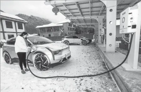  ?? WEN LIN / FOR CHINA DAILY ?? Top: A villager uses newly establishe­d facilities to charge her electric car in Badong county, Hubei province, on Feb 2.