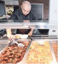  ??  ?? Dr Warren Blake, president of the JAAA, helps himself to some of the delicious dishes.