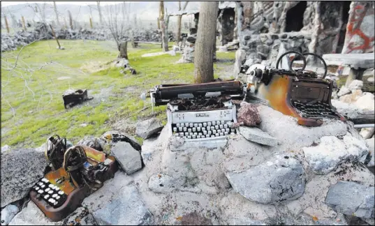  ??  ?? Typewriter­s and other items are incorporat­ed into a fence near the main Thunder Mountain Monument structure.