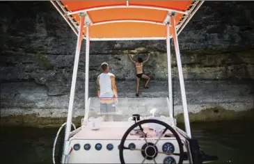  ?? NICK WAGNER/AMERICAN-STATESMAN PHOTOS ?? Fit City writer Pam LeBlanc climbs up a rock face as Adam Mitchell of Rock-About Climbing Adventures looks on while deep-water soloing over Lake Travis in Spicewood on July 6.