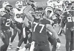  ?? GEORGE WALKER IV/ THE TENNESSEAN ?? Titans tackle Taylor Lewan calls for the fans to cheer after a TD by running back Derrick Henry ( 22) on Tuesday.