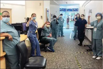  ?? The Associated Press ?? NURSED UNITED: In this image provided by Lizabeth Baker Wade, nurses at Providence Saint John’s Health Center in Santa Monica, Calif., raise their fists in solidarity on April 10 after telling managers they can’t care for COVID-19 patients without N95 respirator masks to protect themselves. The hospital has suspended ten nurses from the ward, but has started providing nurses caring for COVID-19 patients with N95 masks.