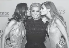  ?? PATRICK KOVARIK, AFP/GETTY IMAGES ?? Bella, left, and Gigi Hadid kiss their mom. Hadid’s son, Anwar, also is a model.