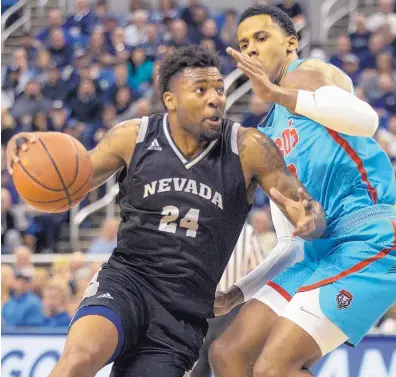  ?? TOM R. SMEDES/ASSOCIATED PRESS ?? Nevada’s Jordan Caroline, left, drives past New Mexico’s Vance Jackson during Saturday’s game in Reno. Caroline scored 13 points as the Wolf Pack avenged a loss to the Lobos earlier this season in Albuquerqu­e.