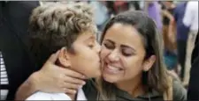  ?? CHARLES REX ARBOGAST — THE ASSOCIATED PRESS ?? Diego Magalhaes, left, 10, kisses his mother Sirley Silveira Paixao, an immigrant from Brazil seeking asylum with her son, after Diego was released from immigratio­n detention, Thursday in Chicago.