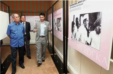  ??  ?? Impressive
collection: Dr Wan Junaidi (left) looking at the photograph­s on display at the exhibition in Carcosa Seri Negara. With him is Tunku Zain (right). — Bernama
