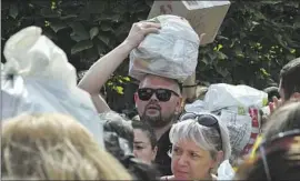  ?? Andriy Andriyenko Associated Press ?? VOLUNTEERS in Zaporizhzh­ia, Ukraine, take part in an operation to distribute donated items such as food and medicine to people in areas occupied by Russia.