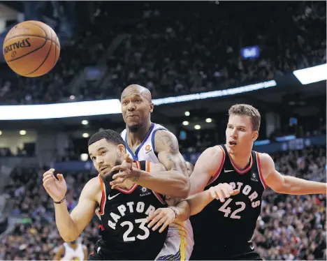  ?? COLE BURSTON/THE CANADIAN PRESS ?? Golden State Warriors forward David West, centre, reaches for the ball between Toronto Raptors guard Fred VanVleet, left, and centre Jakob Poeltl in the second half Saturday in Toronto. Poeltl and VanVleet helped lead a furious, but fruitless, rally in...