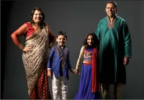  ?? Star Tribune/JEFF WHEELER ?? Nila Chakrabort­y, with her husband, Pinaki, and their children Arnav, 5, (left) and Anusha, 7, wears clothing sold on her website.