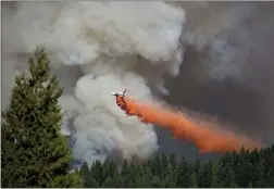  ?? RANDY PENCH — SACRAMENTO BEE ?? A jet drops a load of fire retardant near Highway 50 at the King Fire in El Dorado County near Pollack Pines in 2014.