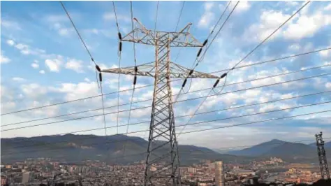  ?? // EFE ?? Una torre de transporte de energía pertenecie­nte a Red Eléctrica, con la ciudad de Bilbao al fondo
