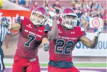 ?? GARY MOOK/FOR THE JOURNAL ?? New Mexico State’s Javahn Fergurson, left, and Shamad Lomax celebrate a defensive stop early in the home loss to Troy.