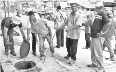  ??  ?? Taren Sunil (second right) with the joint team inspecting one of the manholes at the MPS flats at Karamuntin­g.