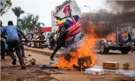  ?? Photograph: Badru Katumba/AFP/Getty Images ?? A supporter of Ugandan musician turned politician Robert Kyagulanyi, also known as Bobi Wine, carries his poster as protests continue over his arrest.